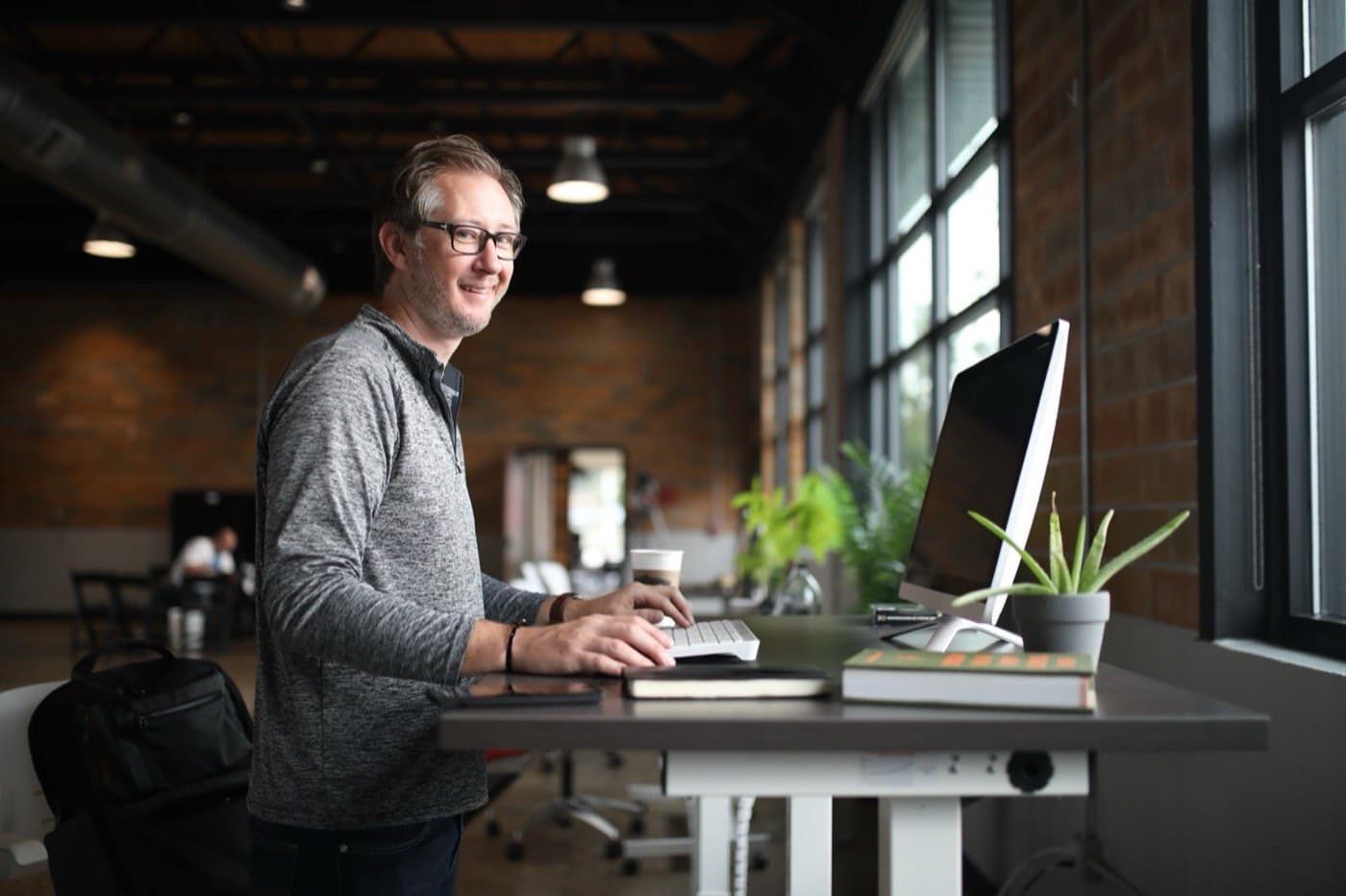 Professional smiling at a modern office standing desk